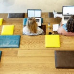 two women sitting on a stair with their laptops